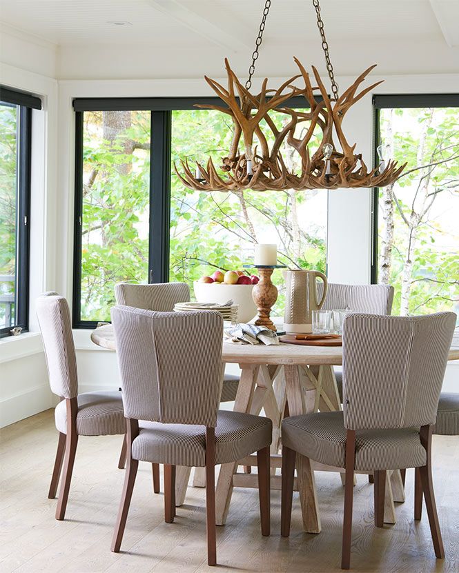 dining area with table, antler chandelier, and large windows